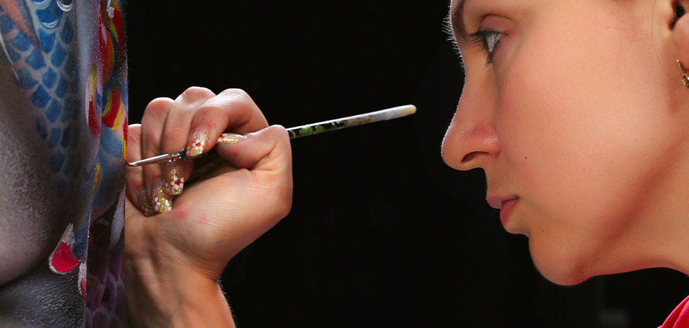 artista che dipinge sulla schiena del modello